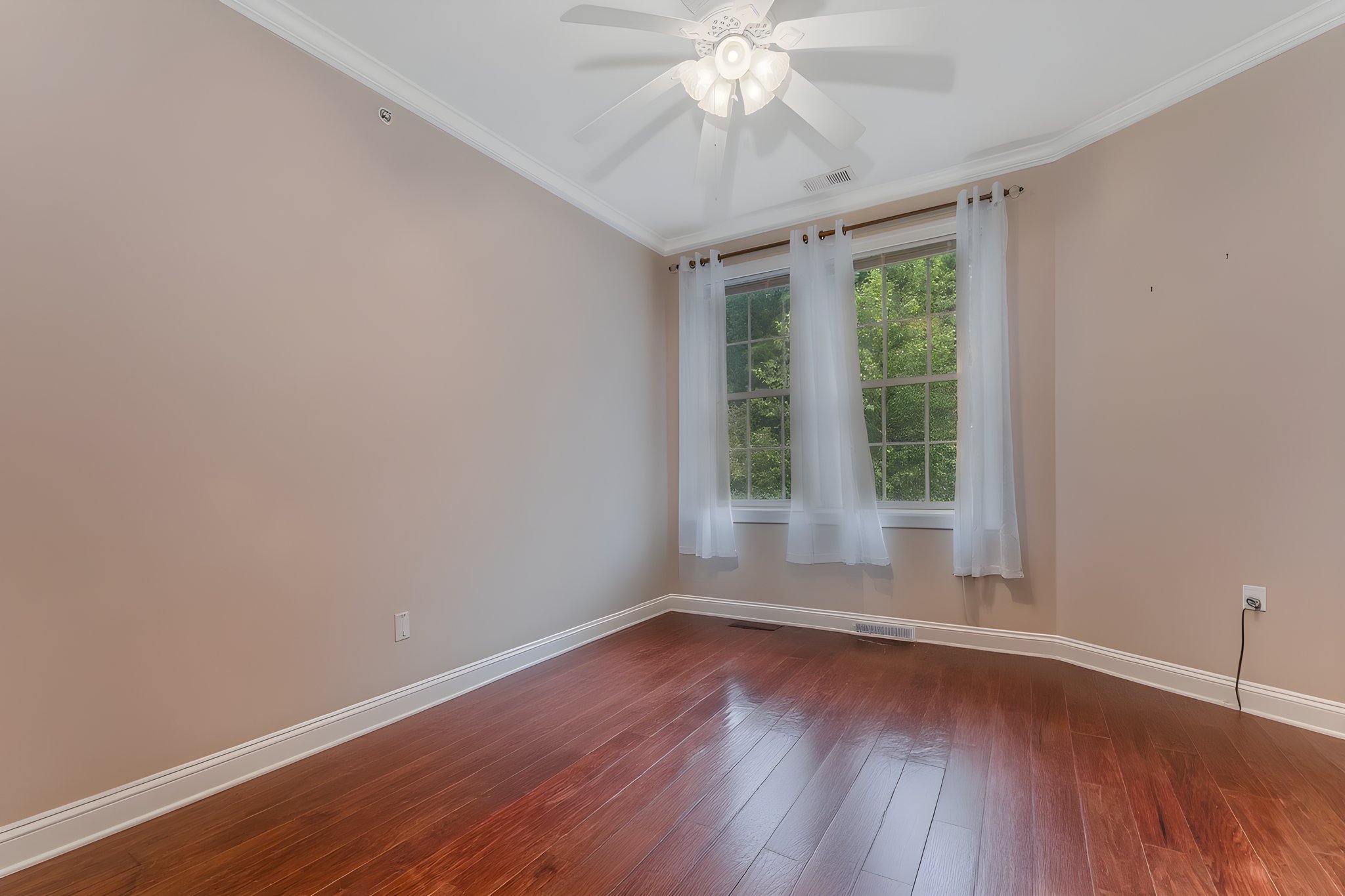 Furniture Removed/Virtually Staged Bedroom 2 features hardwood flooring and walk-in closet. The closet was converted into a pantry, with built-in shelving for organized storage.