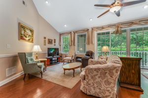 Living Room A full wall of windows & sliding doors fill the space w natural light & open to a private balcony overlooking a peaceful wooded setting.