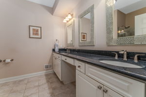 Master Bath The ensuite bath features double sinks and a make-up counter in a white vanity, and a shower in tile surround with bench seating and frameless glass door.