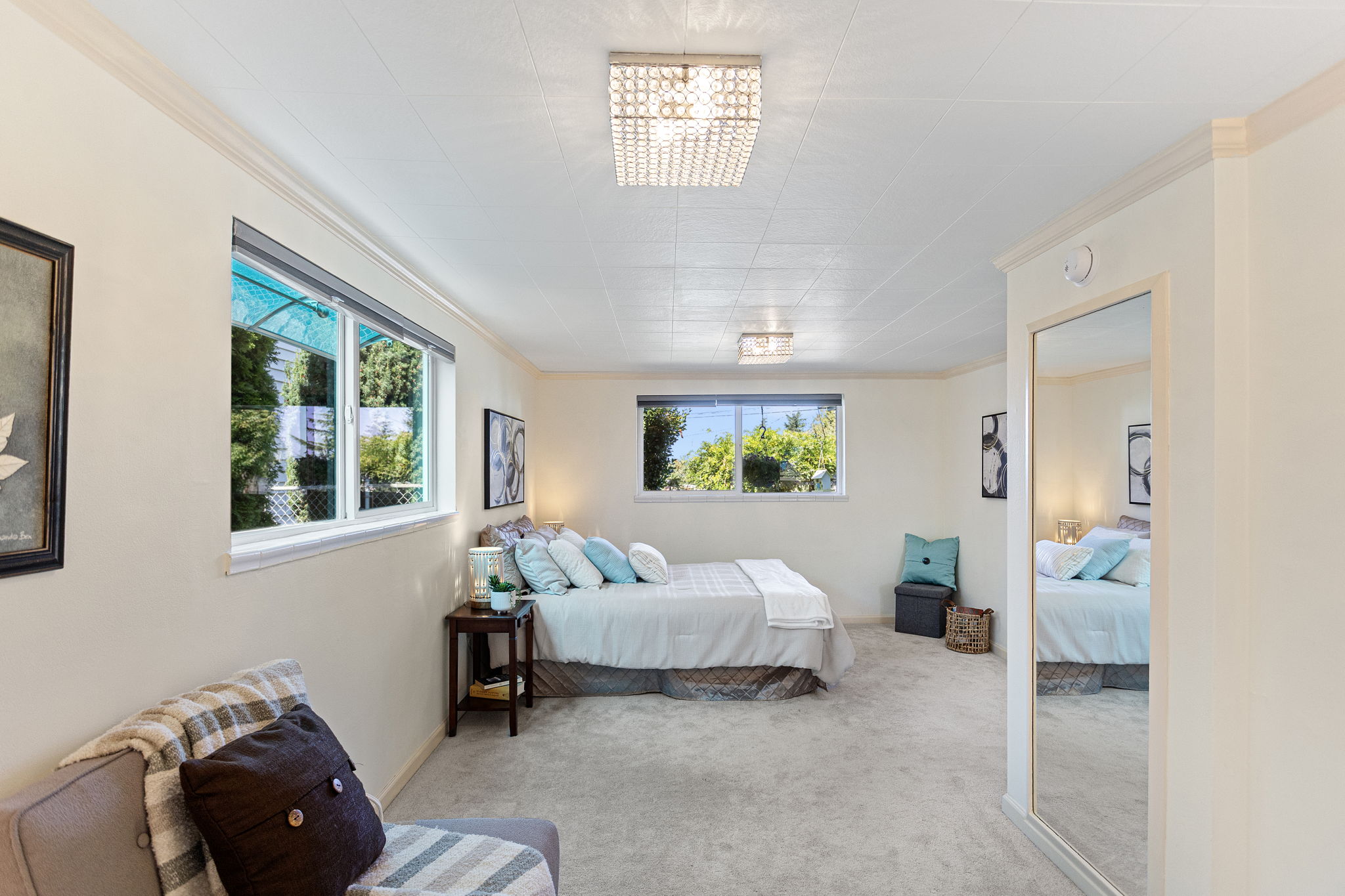 The main-level bedroom is unusually generous, with room for a full bedroom setup plus a separate sitting area.