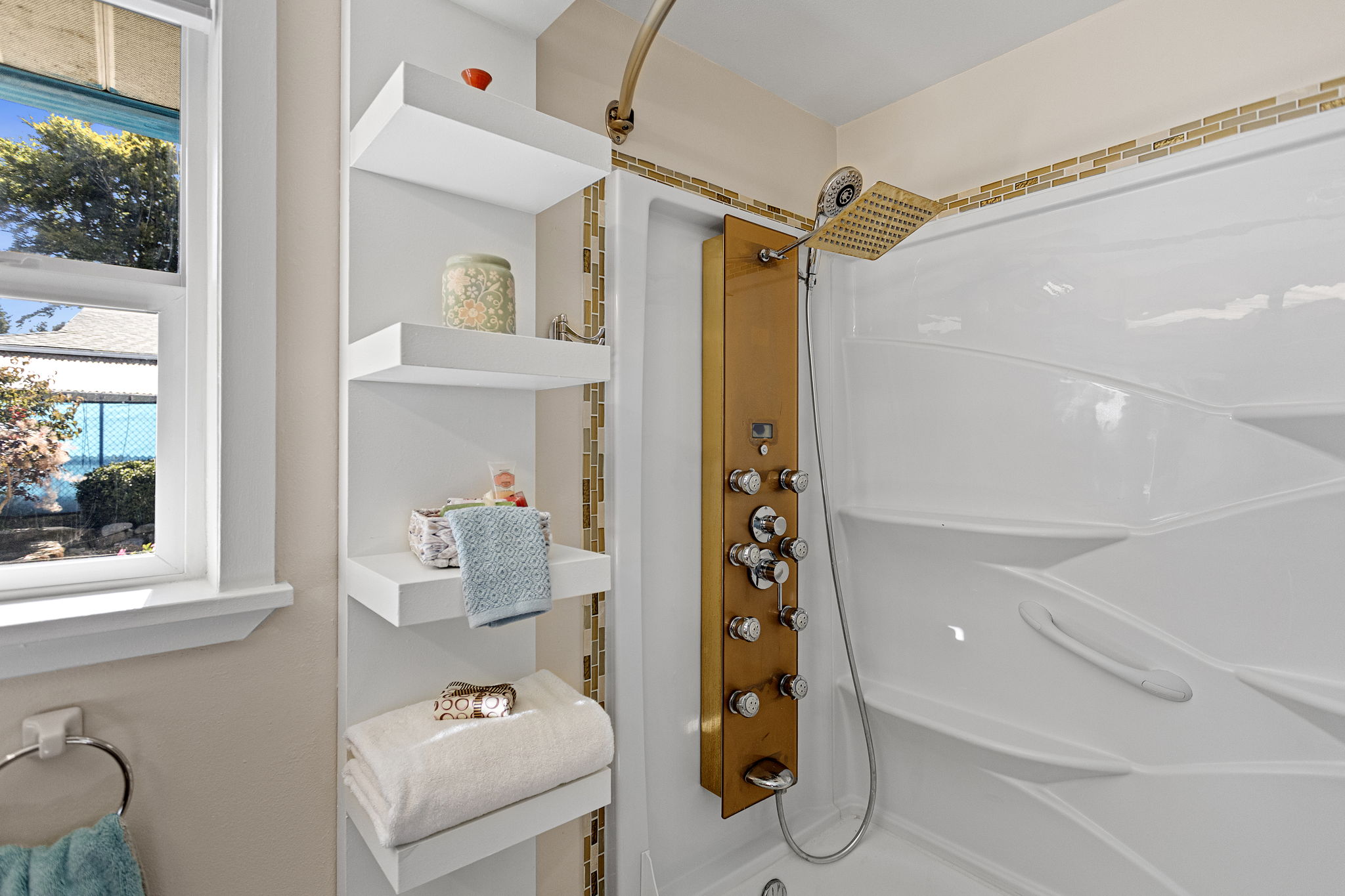 The full bath continues with a multi-function shower panel, rain head and built-in shelving for a little extra daily luxury.