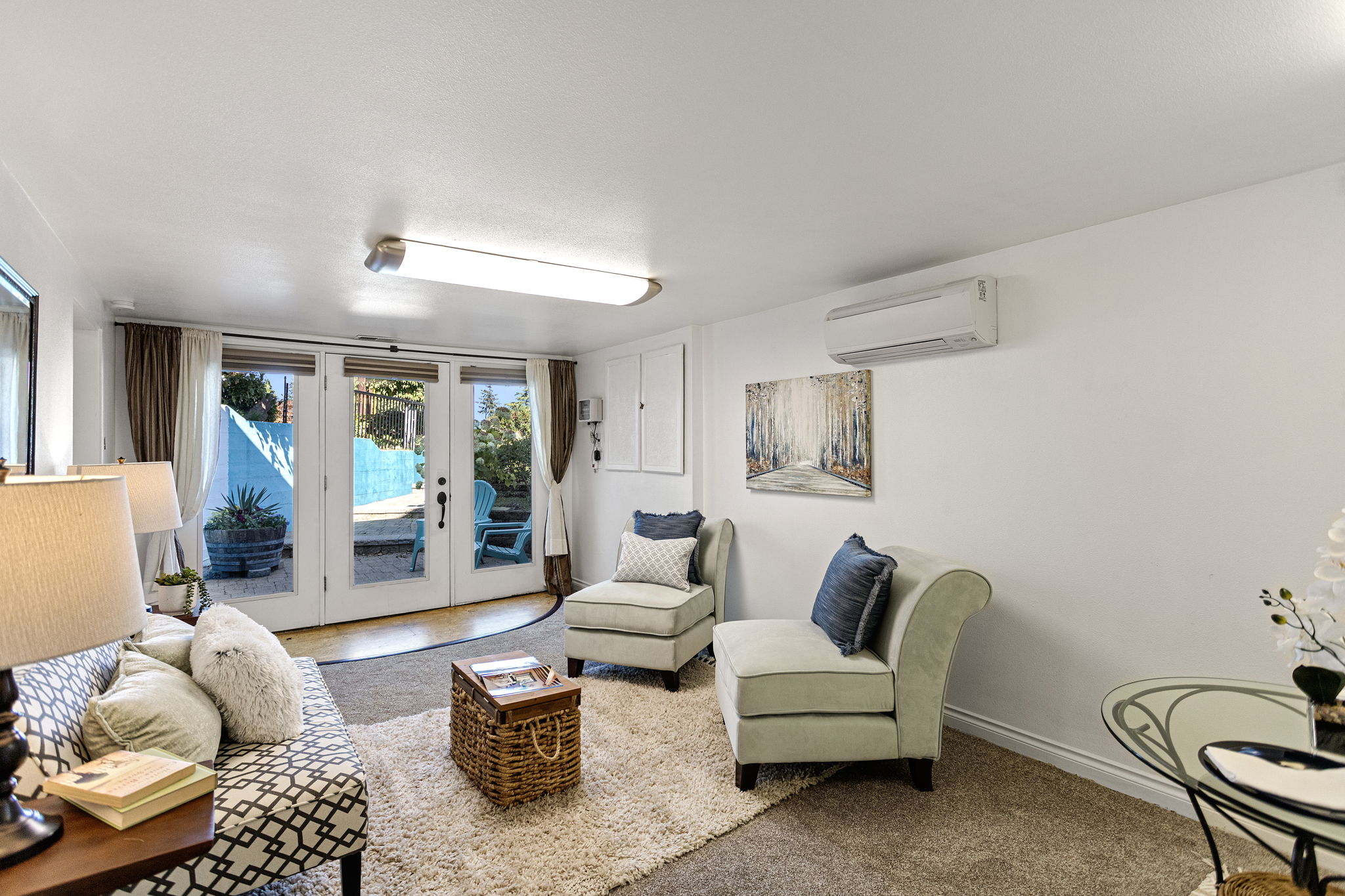 The lower living area opens straight to the hardscaped patio through French doors, with a dedicated ductless mini-split for heating and A/C.