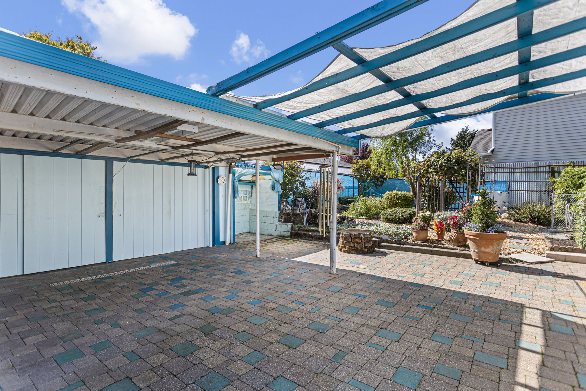 The covered patio/carport adds a big dose of flexibility, with double doors opening to abundant outdoor storage and room to imagine workshop, hobby or creative use.