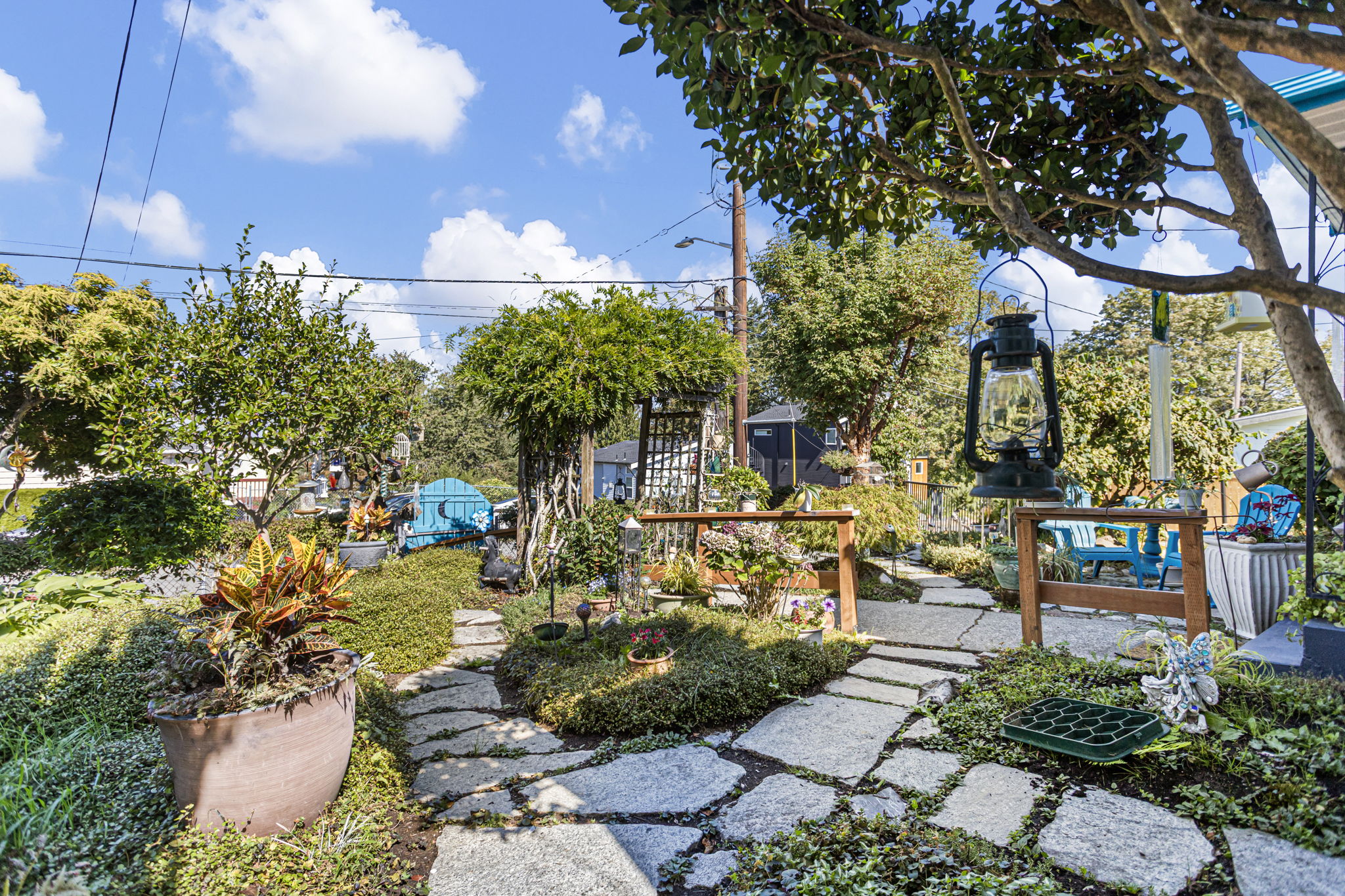Collected, not landscaped by formula: winding slate paths, sculpted plantings, garden art and a tucked-away seating area.