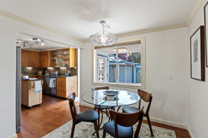 The dining area sits directly off the kitchen, with a broad window bringing in garden light and a view back to the sunny south-facing garden.