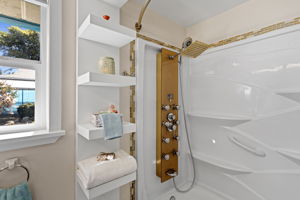 The full bath continues with a multi-function shower panel, rain head and built-in shelving for a little extra daily luxury.