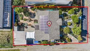 Aerial view puts the whole property in context: the 4,673 sq ft lot, rear garden, covered carport/patio and owned 13-panel solar array. Property outline is approximate, not a survey.