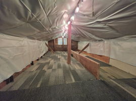 Substantial semi-finished attic storage with carpet and lighting—useful space for keeping everyday living areas uncluttered.