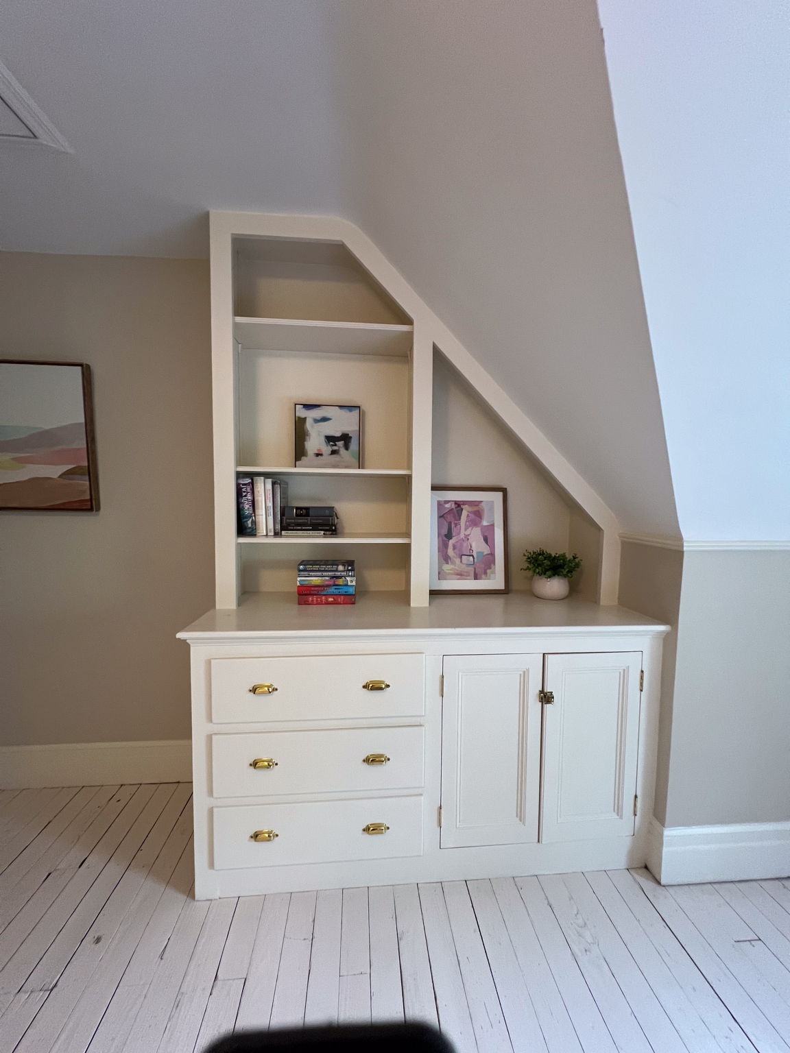 Tucked beneath the slope of the ceiling, this bespoke bookshelf turns an architectural quirk into pure magic—because stories deserve a nook as charming as the ones they tell.