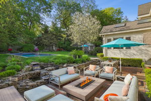 Resort-style outdoor living on a patio featuring a gas fed firepit and waterfall—ideal for lively gatherings or quiet relaxation under the stars.