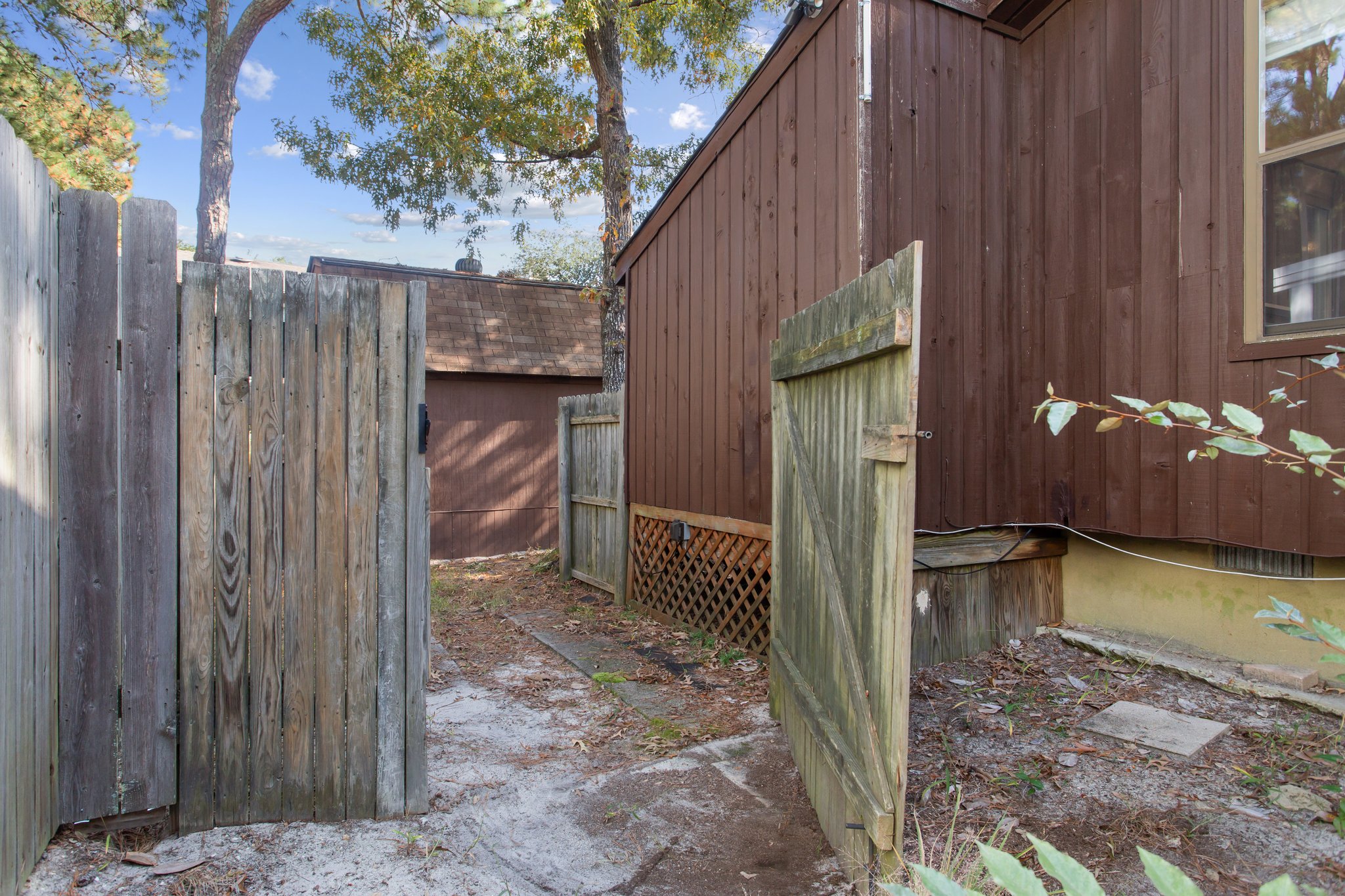 Side yard with double gate, perfect for storing a golf cart for the beach