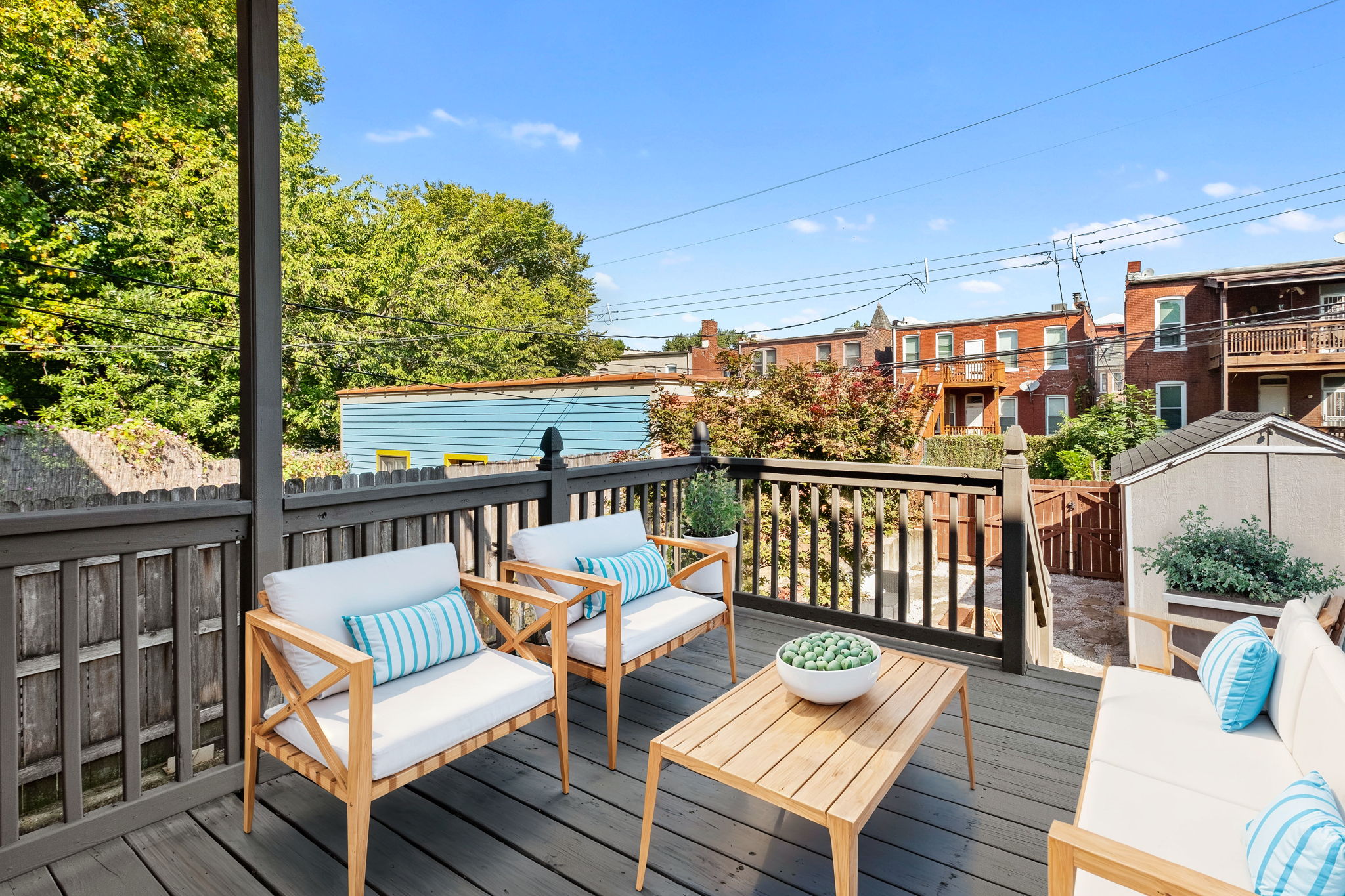 Heading outside, the fully-fenced private backyard has amazing bones from a refurbished deck (2024) to a cozy stone firepit.  This photo has been virtually staged to help a Buyer conceptualize the space.