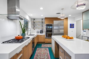 Sleek white counters, warm wood cabinetry, and a generous island that naturally becomes the gathering place for morning coffee, weeknight dinners, and everything in between.