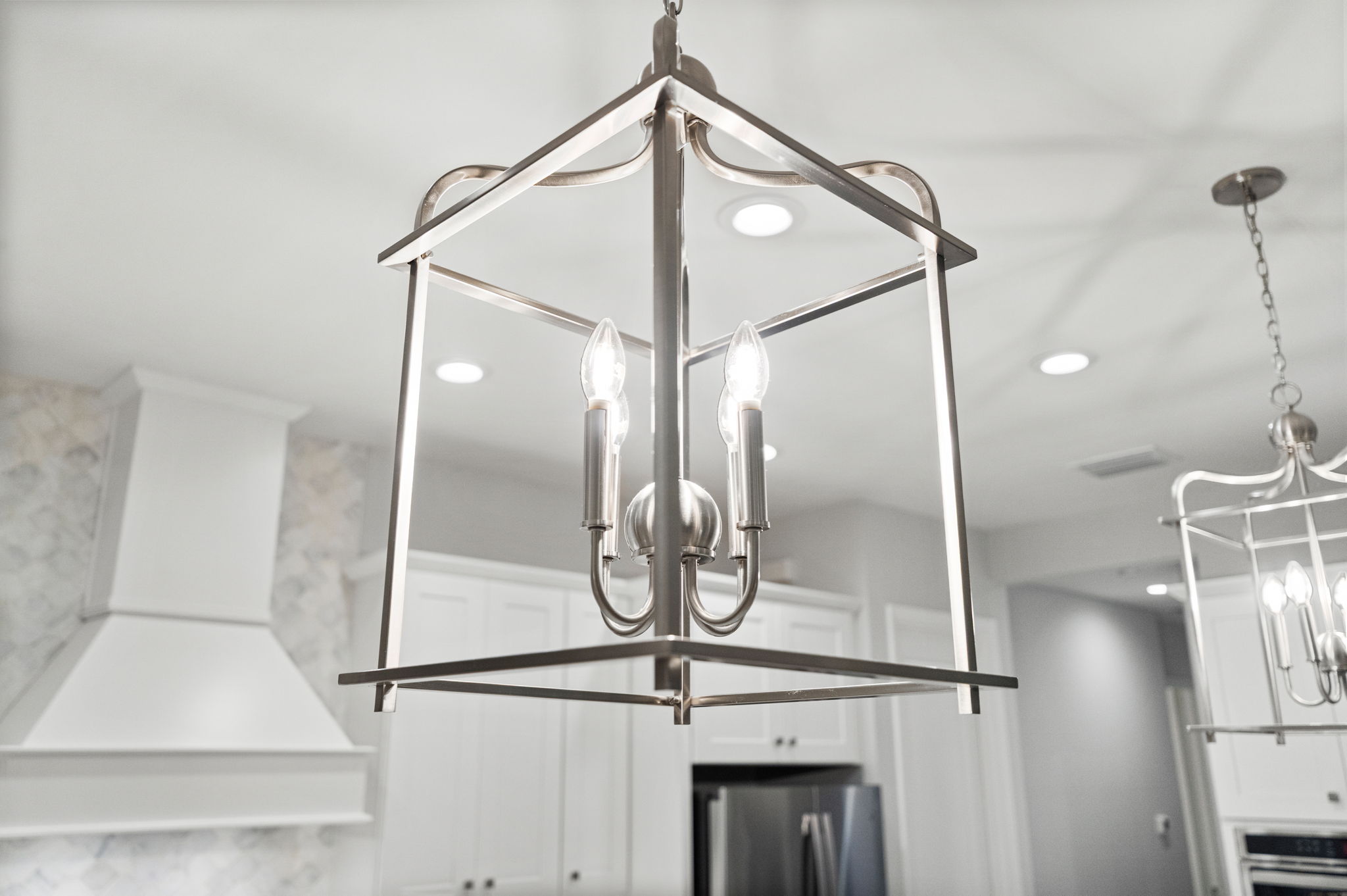 Sleek custom lanterns over island