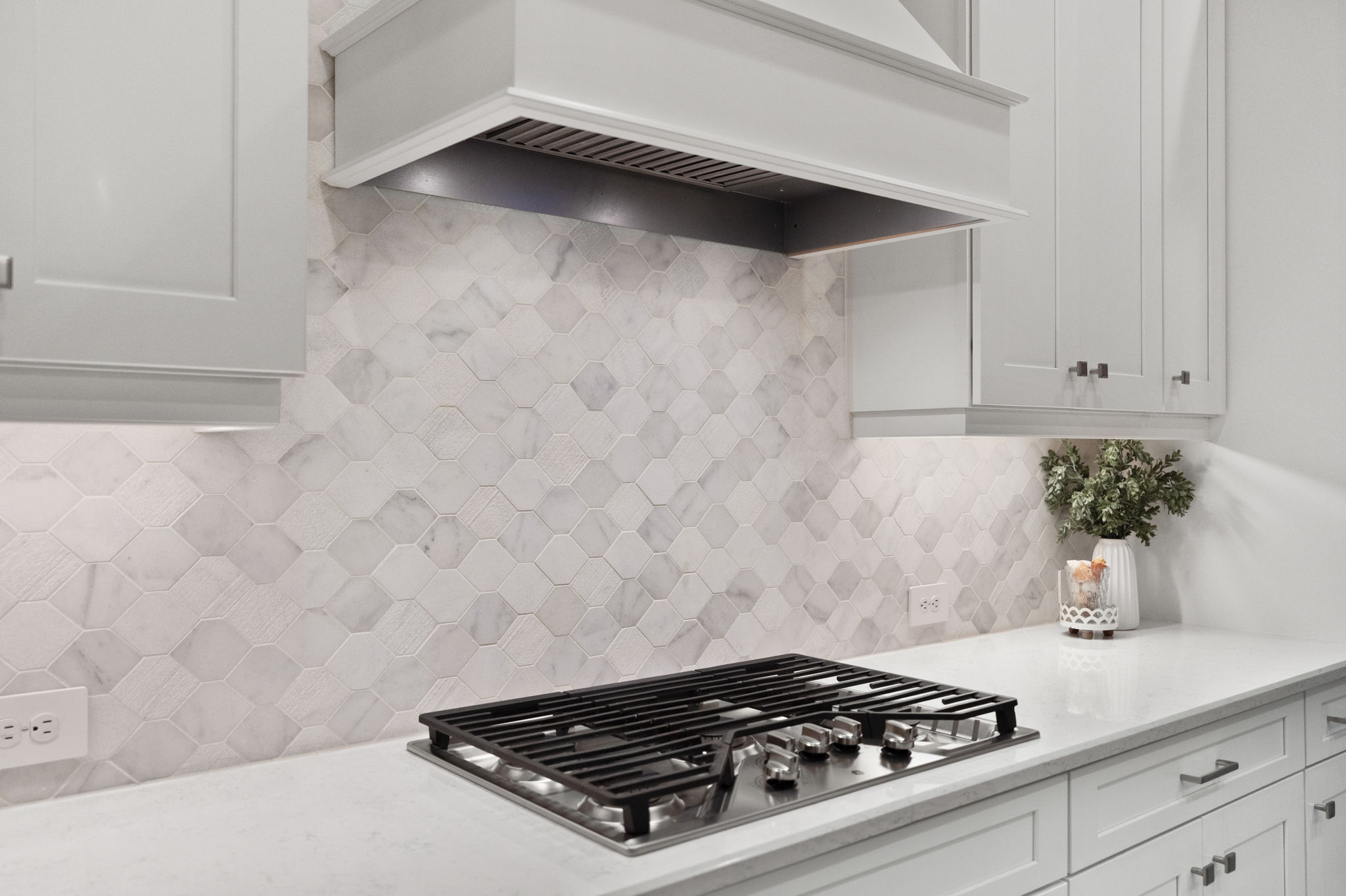 Tile backsplash accented by under cabinet lighting