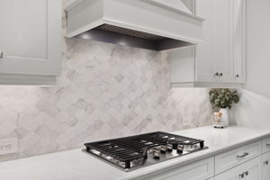 Tile backsplash accented by under cabinet lighting