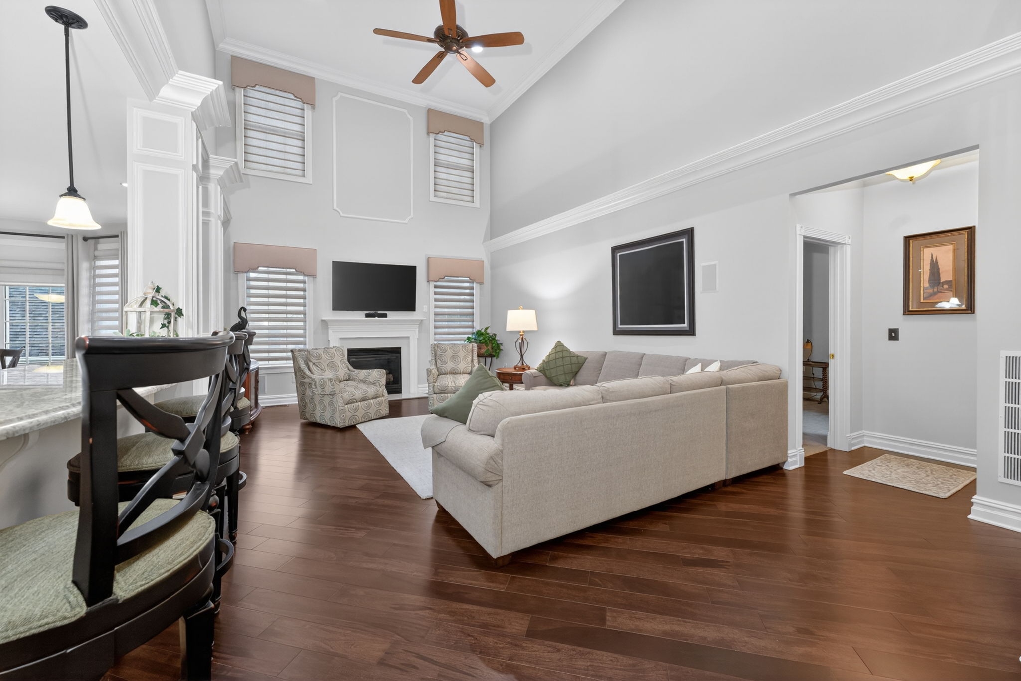 TWO STORY FAMILY ROOM Marble surround fireplaces with custom mantel adds understated sophistication to the dramatic two-story family room. Additional features include recessed lighting, ceiling fan, custom mouldings and wainscoting, 2 story windows.
