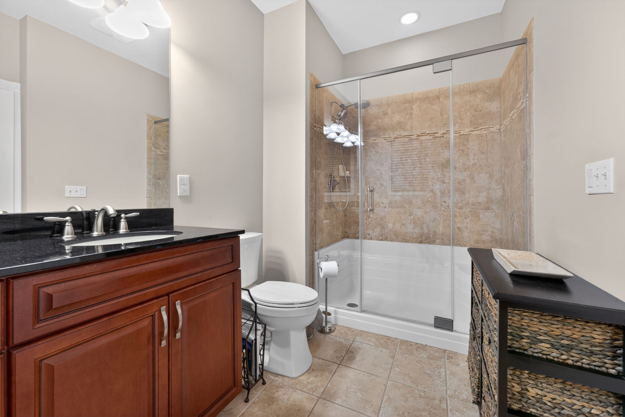 Relax and unwind in the luxurious en suite bath featuring a soaking tub, dual sinks set in a granite-top vanity, and an oversized tiled shower with pivot swing door and ceramic tile flooring.