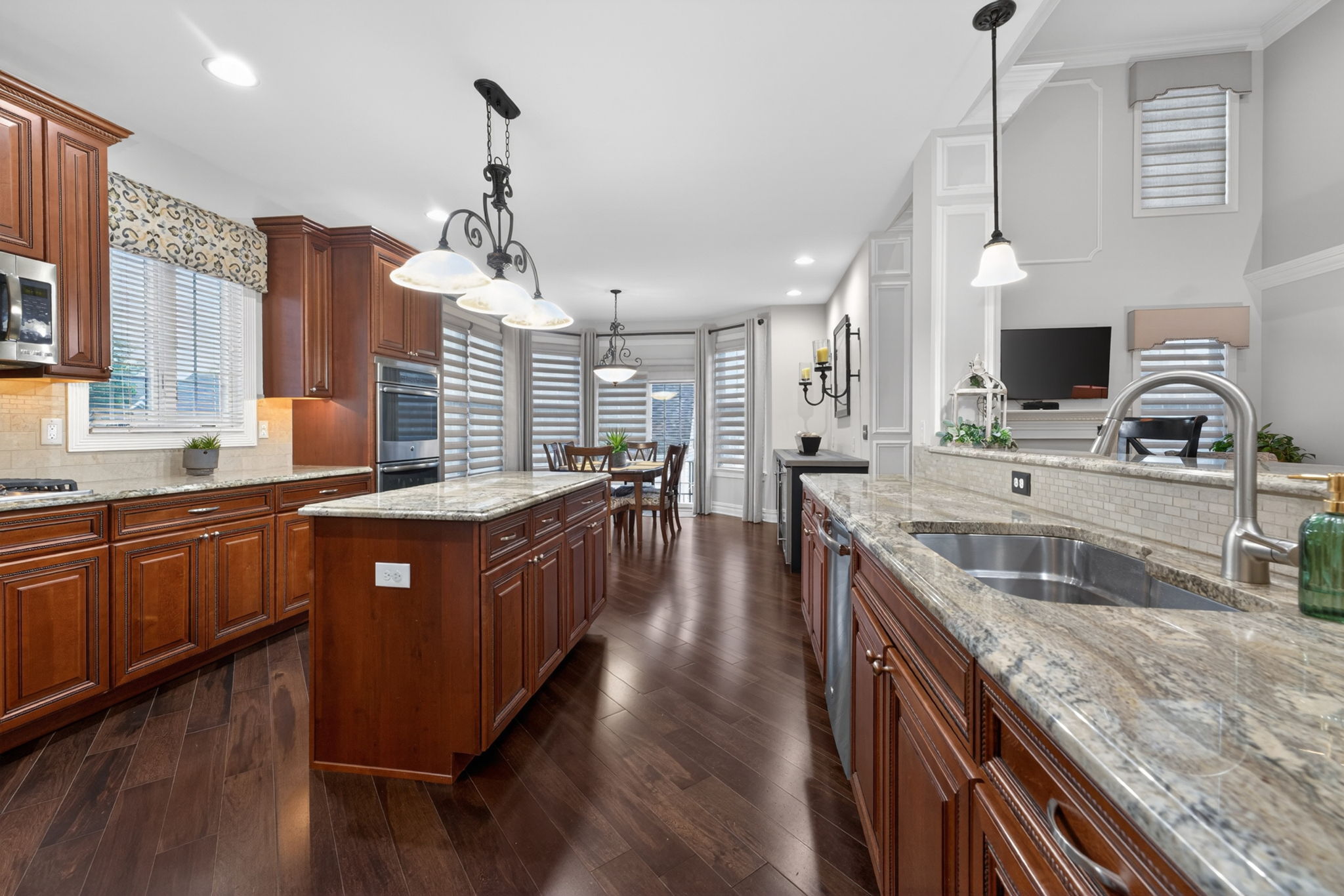 The gourmet kitchen is a true culinary workspace, thoughtfully designed with an abundance of beautiful cabinetry, granite countertops, and high-end stainless steel appliances.