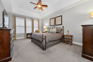 Primary Suite Features of the primary suite include a deep tray ceiling, ceiling fan, 2 walk in closets (1 with built-in organizer system), carpeting.