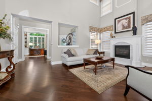 TWO STORY LIVING ROOM Two story living room features custom mouldings and wainscoting, 2 story windows, a gas fire-place with marble surround and custom mantel.