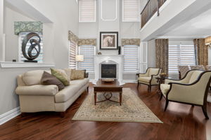 TWO STORY LIVING ROOM Two story living room features custom mouldings and wainscoting, 2 story windows, a gas fire-place with marble surround and custom mantel.