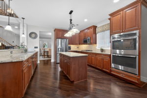 The gourmet kitchen is a true culinary workspace, thoughtfully designed with an abundance of beautiful cabinetry, granite countertops, and high-end stainless steel appliances.