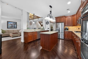A center island prep station and separate granite breakfast bar with seating invite guests to gather and enjoy the cooking experience.