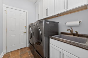 Laundrey Room-Level 1 Shaker style cabinetry, utility sink in cabinet, LG washer and dryer on pedestals, ceramic tile flooring, 2 car garage access.