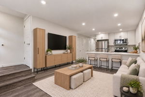 Virtually staged and rendered in #113 finishes. Living room with TV wall, open to the kitchen. Furniture not included.