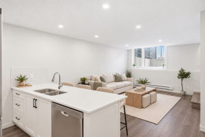 Virtually staged and rendered in #113 finishes. White quartz kitchen peninsula open to the living room. Furniture not included.