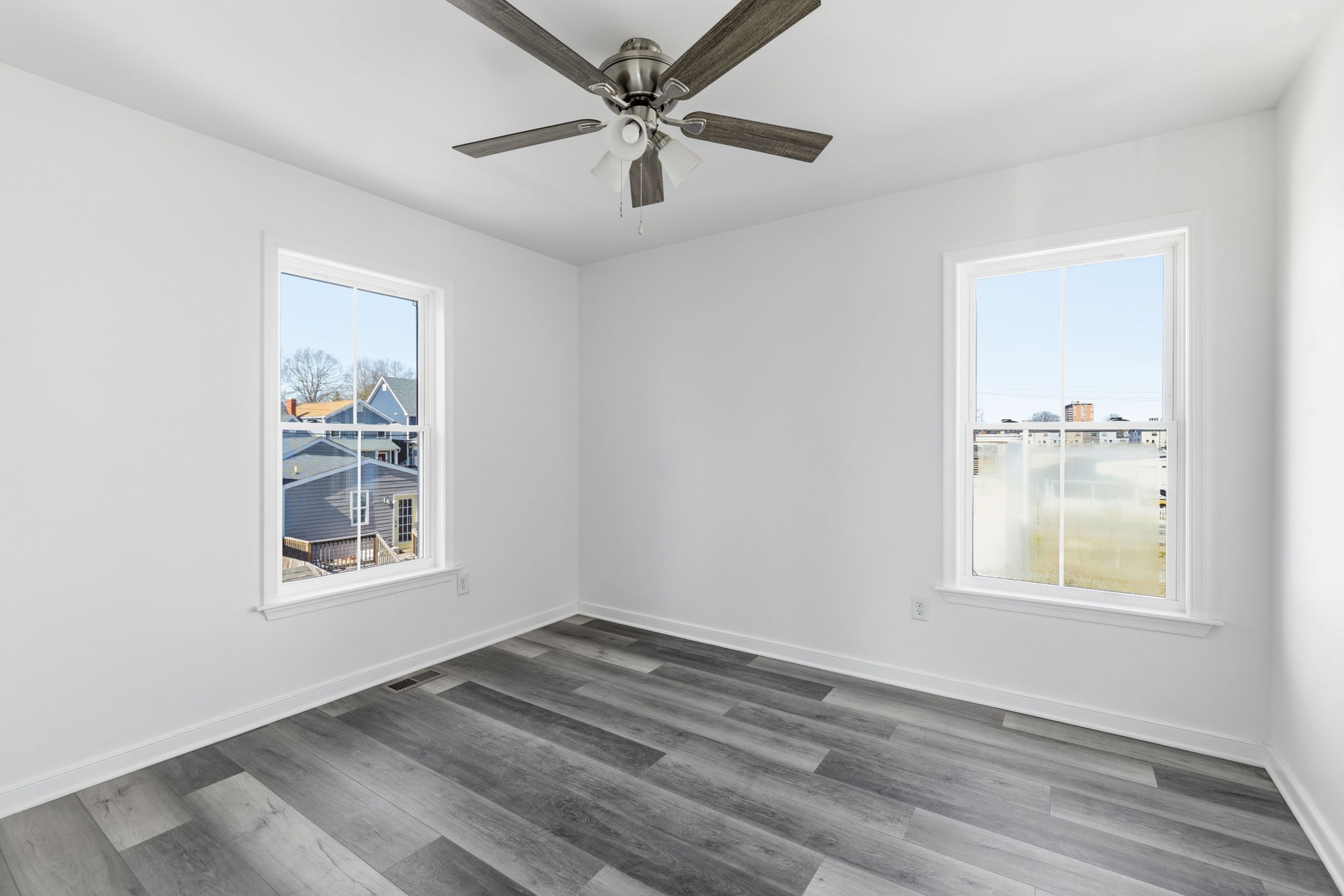 Rear guest bedroom with ceiling fan, LVP flooring, and a nice sized closet.