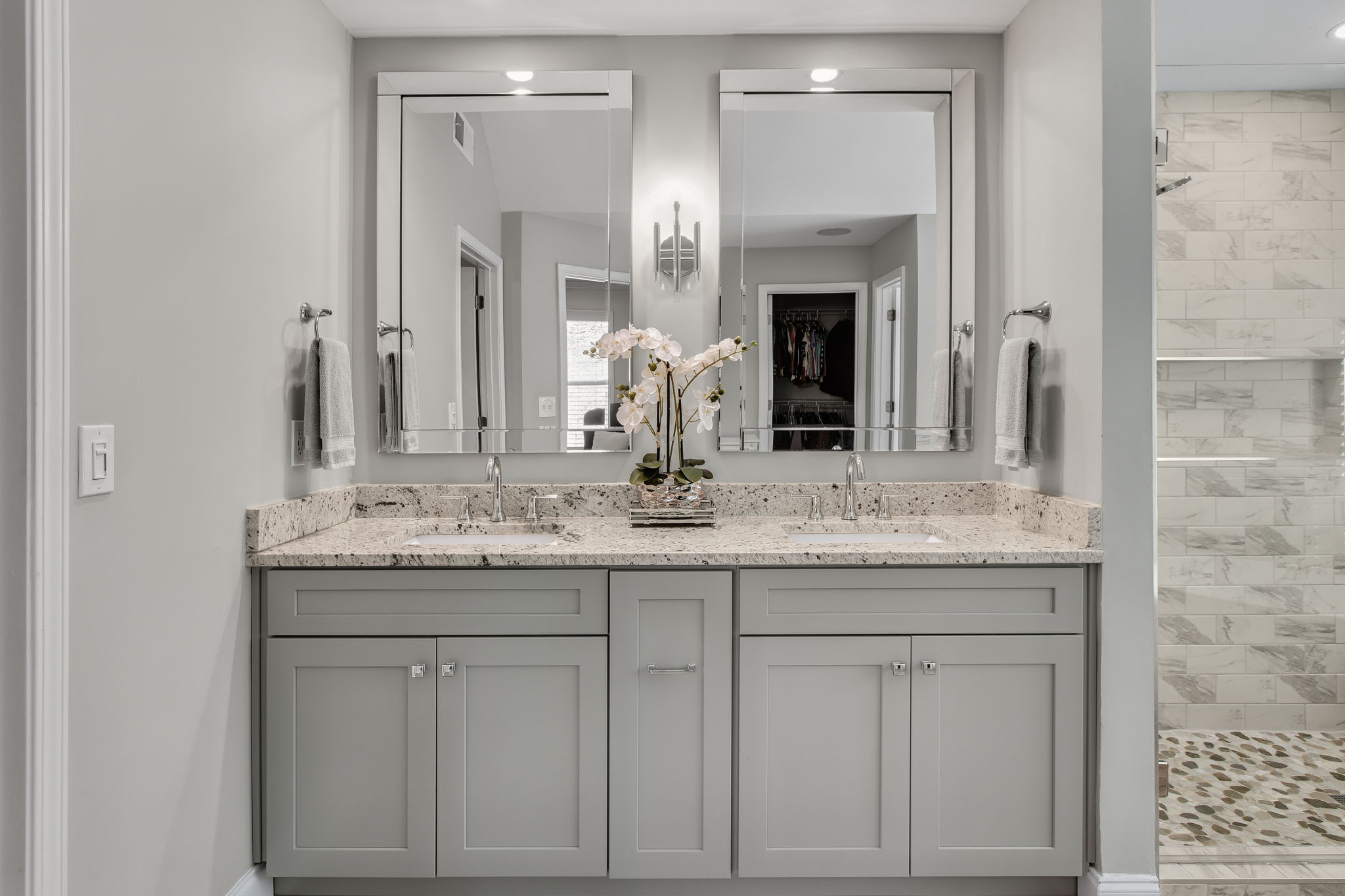 Stylish Dual Vanity Bath – A modern en-suite with sleek cabinetry, polished granite countertops, and elegant framed mirrors.