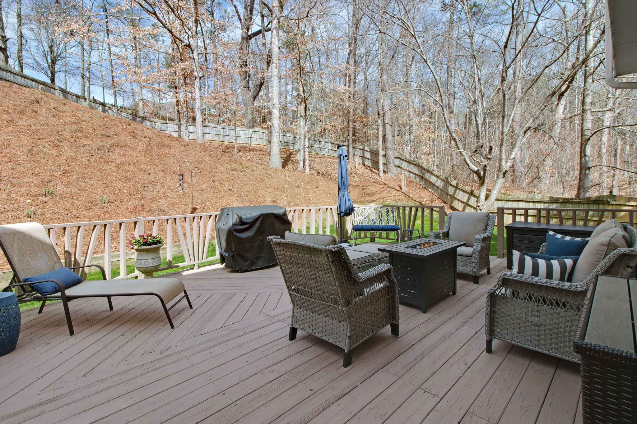 Spacious outdoor deck with ample room for seating and serene wooded views, perfect for entertaining or relaxing.