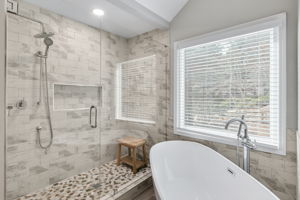 A beautifully tiled walk-in shower with a rainfall showerhead and glass enclosure for a sleek finish.