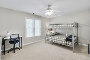 Comfortable and spacious bedroom with ceiling fan and large closet.