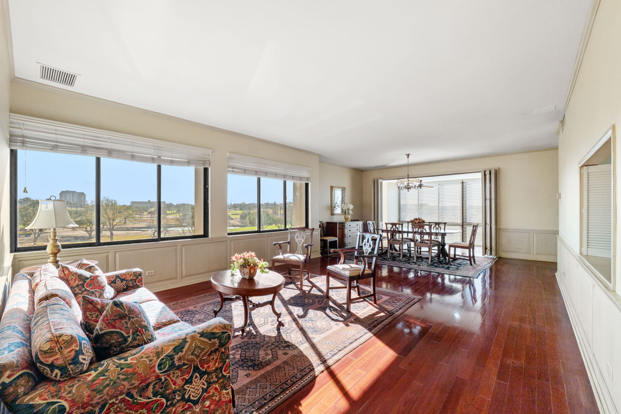 The spacious living room is combined with formal dining along a wall of windows providing incredible views and light