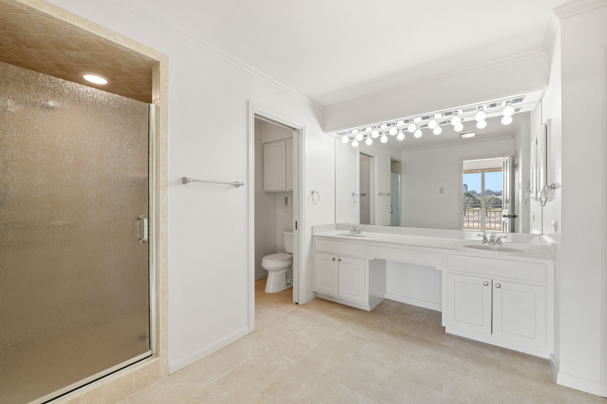 The primary bath includes dual vanities, a large walk-in shower, a separate water closet, and two walk in closets (in addition to the third closet within the bedroom)