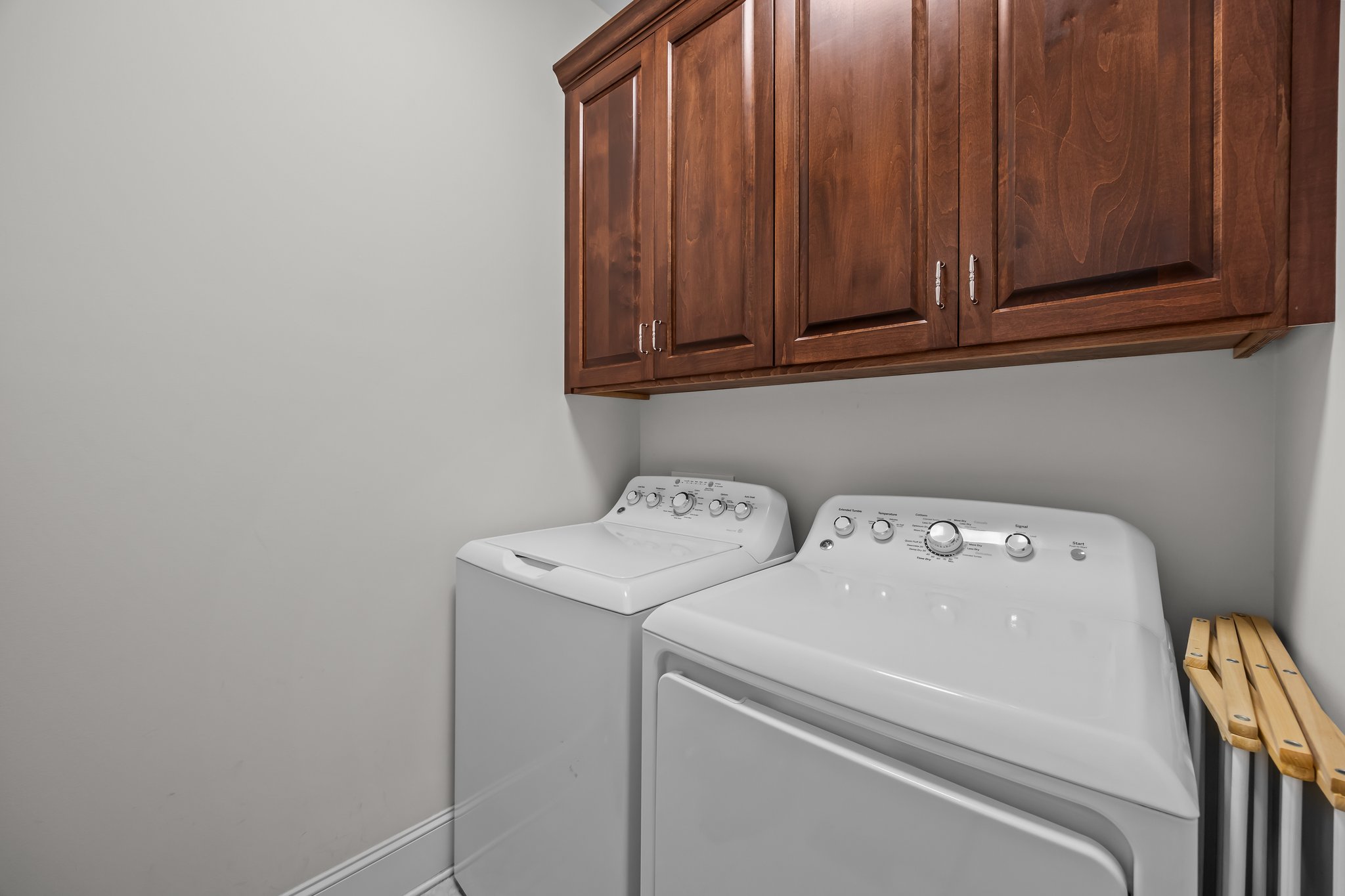 Laundry Room with tile flooring & upper cabinet storage