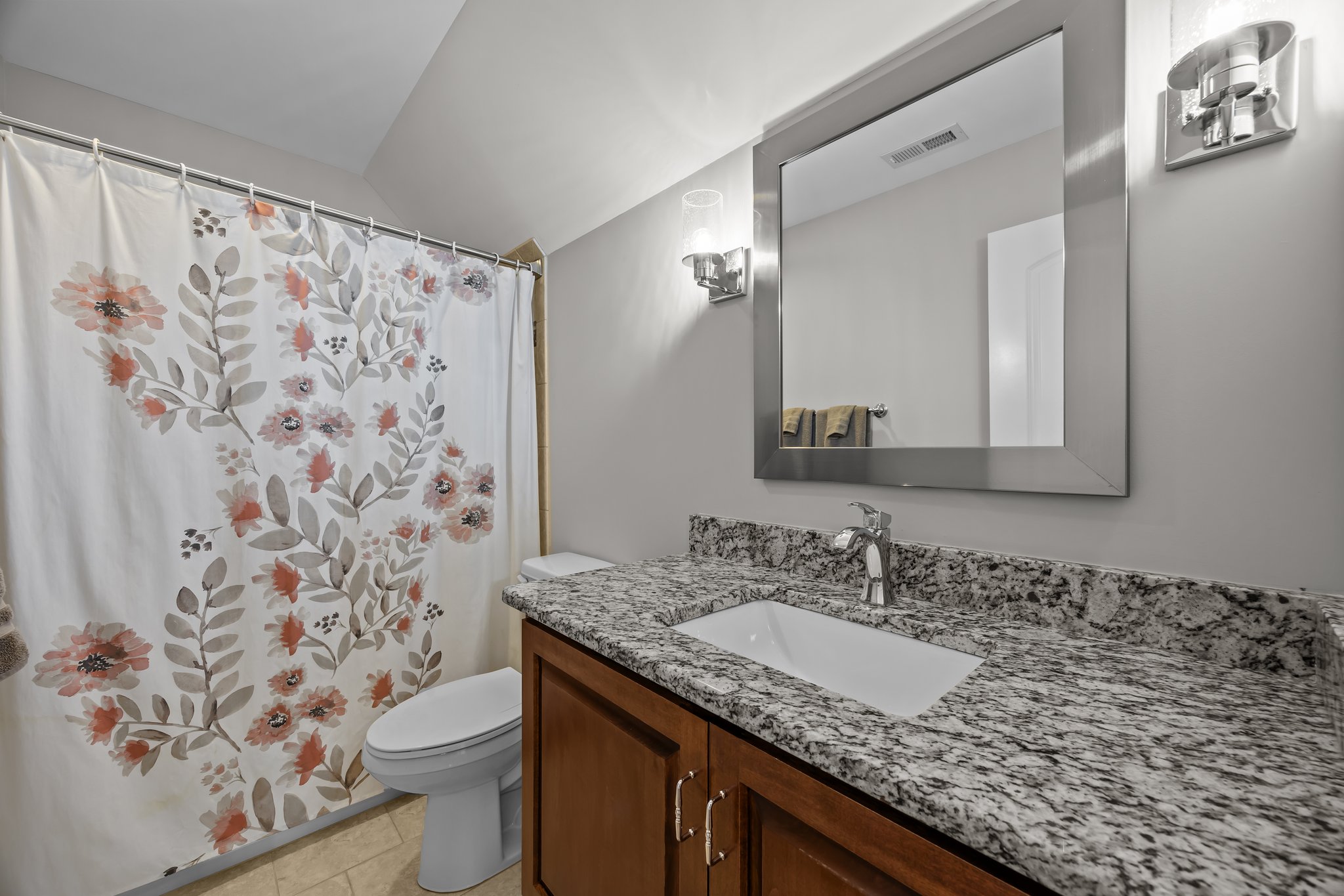 Hall bath, tile shower, sconce style lighting