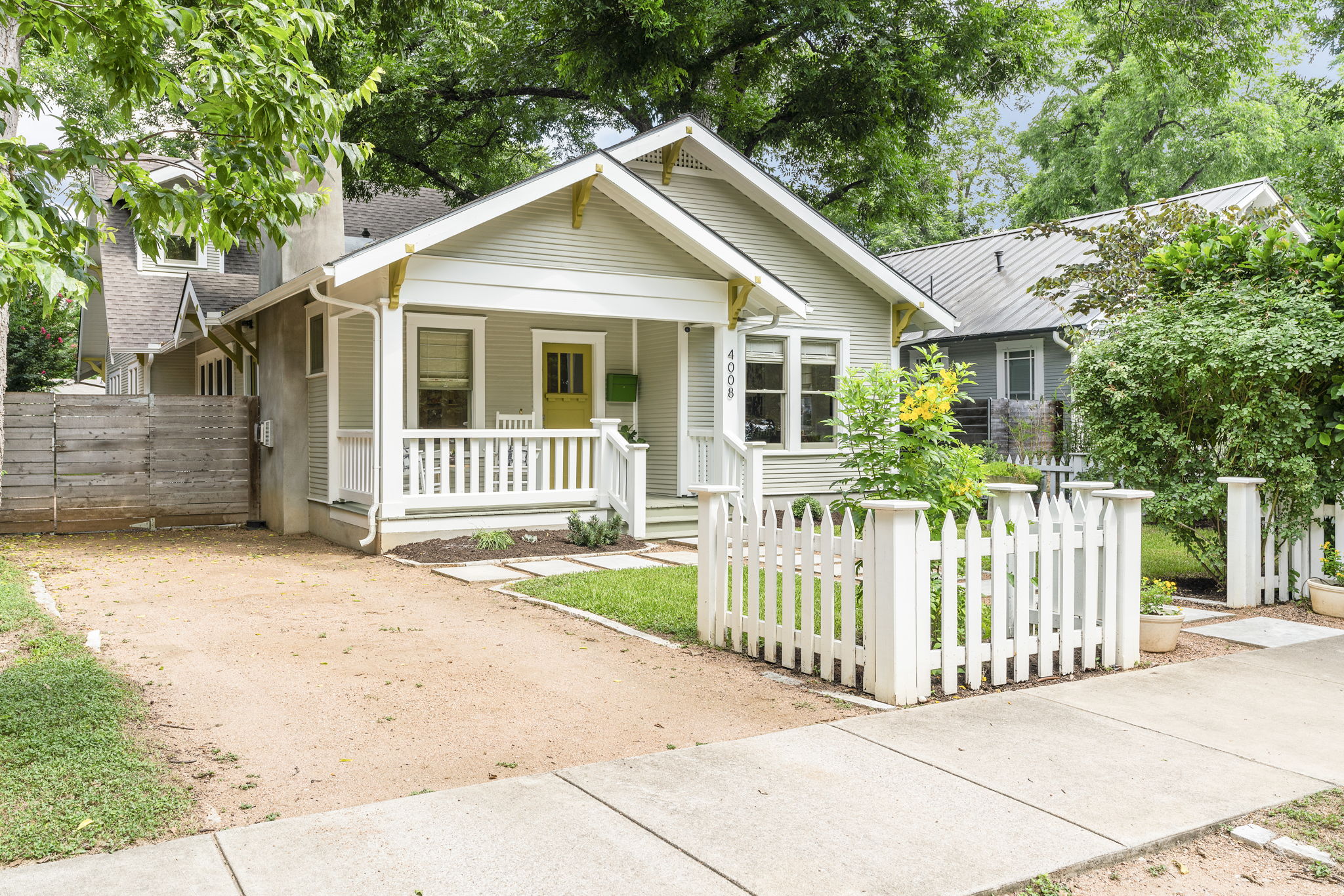 This home exudes charming curb appeal with its classic white picket fence and crushed granite driveway.