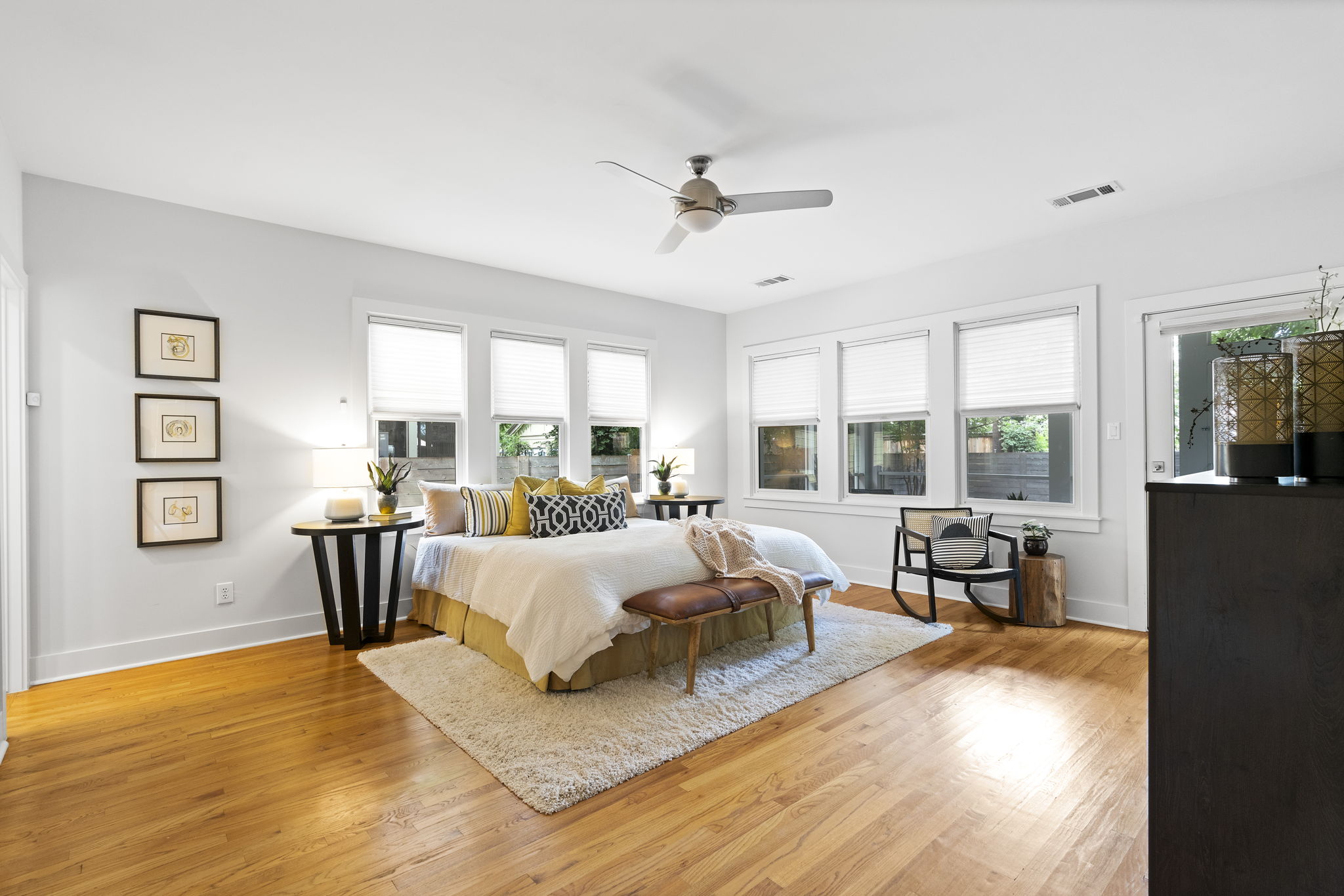 The spacious main bedroom is a peaceful sanctuary bathed in natural light. It offers a view of the backyard and direct access to the screened-in back patio, perfect for relaxing evenings.