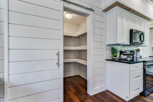 Spacious pantry accented by a sliding ship-lapped door