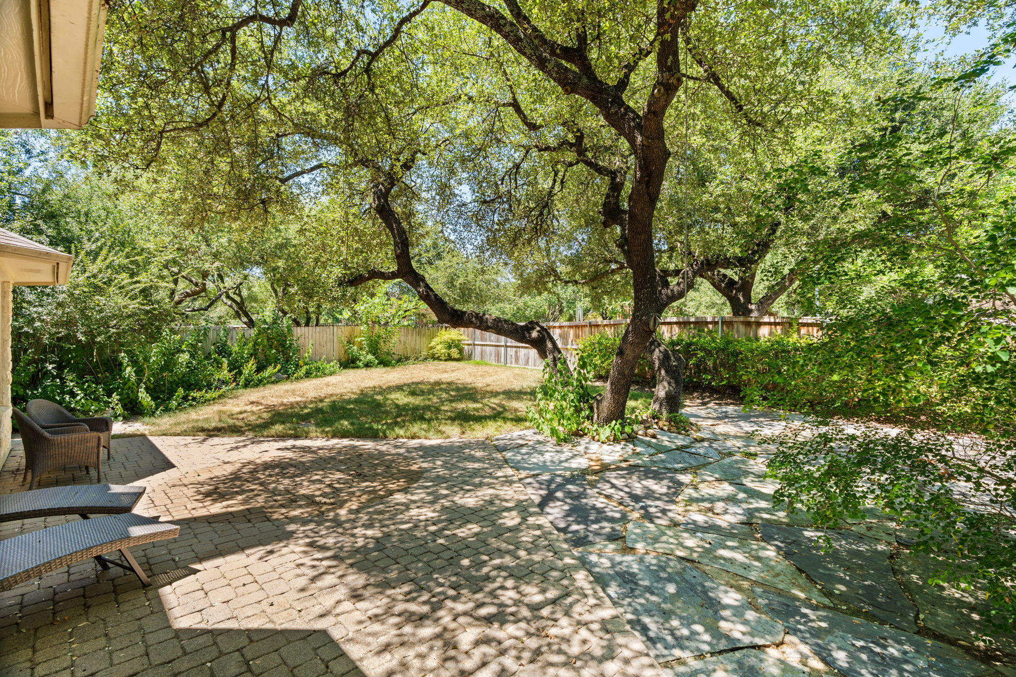 Framed by majestic oak trees, the home greets you with immediate beauty, setting the tone for the interior's natural elegance.
