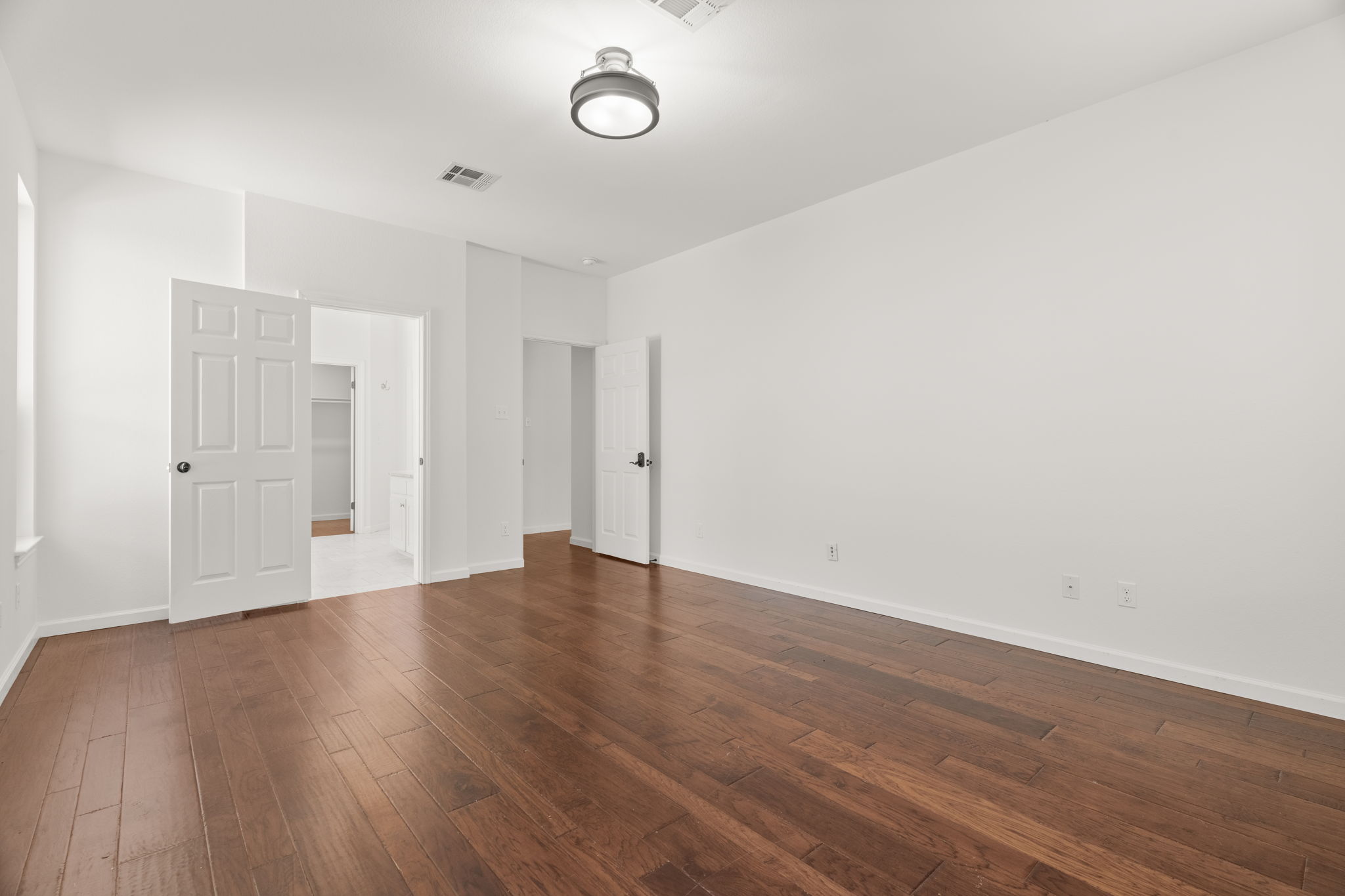 The main-level primary suite serves as a true retreat, featuring a double, distinctive vanity, jetted tub, separate shower, and a spacious walk-in closet.