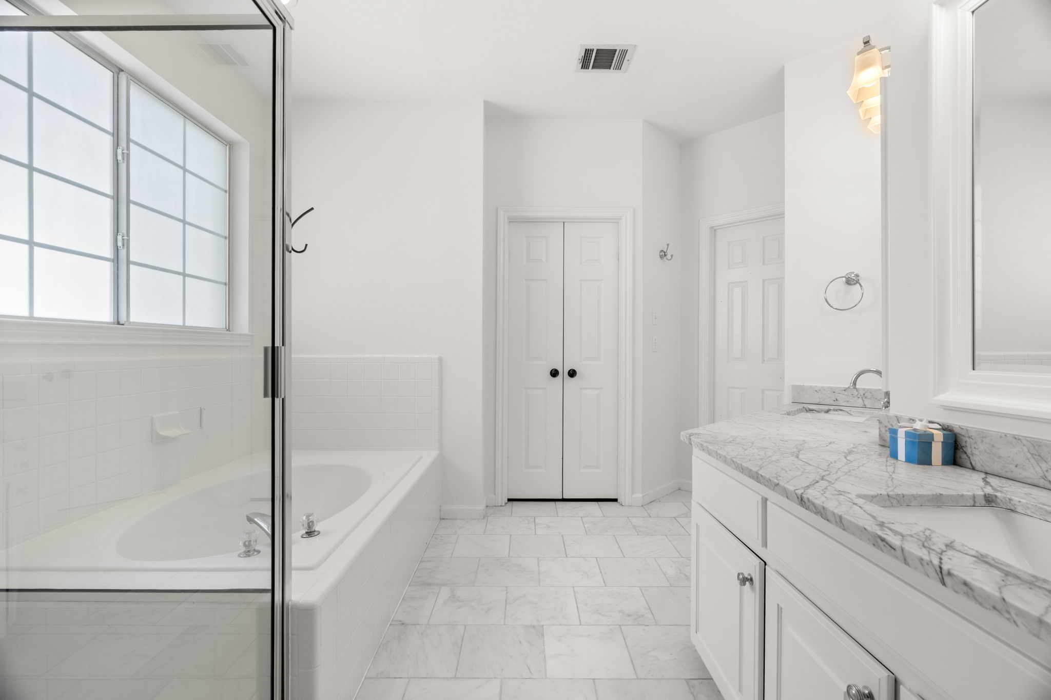 The main-level primary suite serves as a true retreat, featuring a double, distinctive vanity, jetted tub, separate shower, and a spacious walk-in closet.