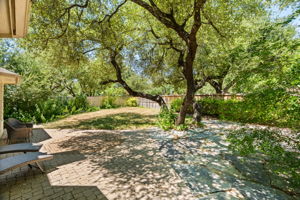 Framed by majestic oak trees, the home greets you with immediate beauty, setting the tone for the interior's natural elegance.