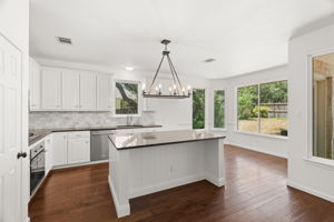 At the heart of the home, the light-filled, well-appointed kitchen boasts a center island, gas cooktop, ample cabinetry and a cozy dining nook overlooking the lush backyard.