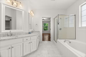 The main-level primary suite serves as a true retreat, featuring a double, distinctive vanity, jetted tub, separate shower, and a spacious walk-in closet.