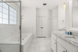 The main-level primary suite serves as a true retreat, featuring a double, distinctive vanity, jetted tub, separate shower, and a spacious walk-in closet.